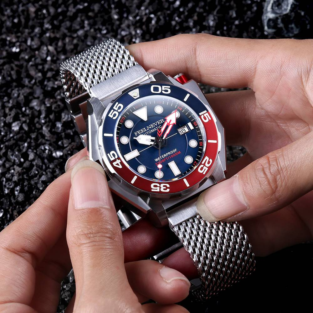 Person holding a silver watch with a blue and red face
